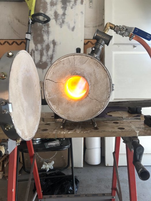 Hemmagjord mini-ässja med igångsatt brännare, glödande öppning och mässingskopplingar.