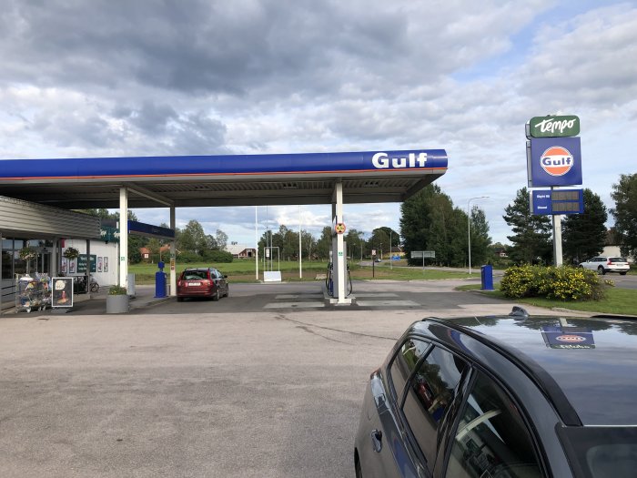 Gulf bensinstation med bil och skylt för Tempo i Nås, Dalarna under molnig himmel.