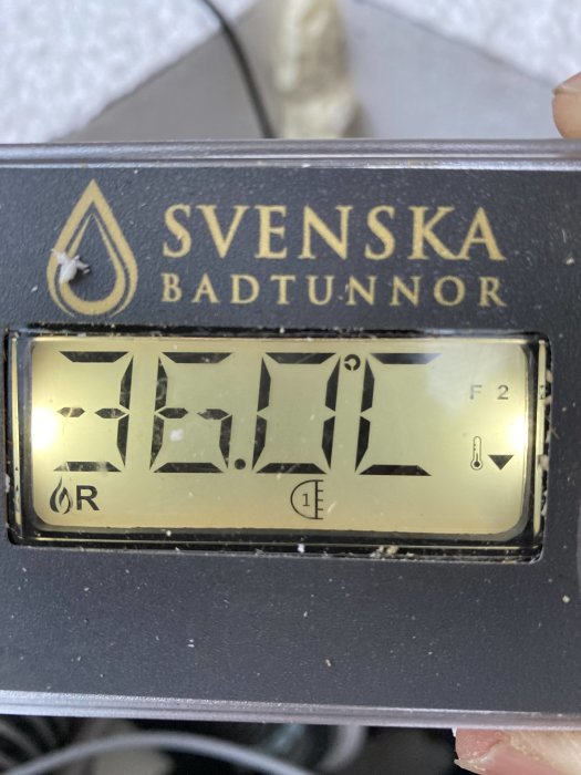 Digital display på poolutrustning visar 33.0 och en symbol föreställande halvcirkel med streck och en '1'.