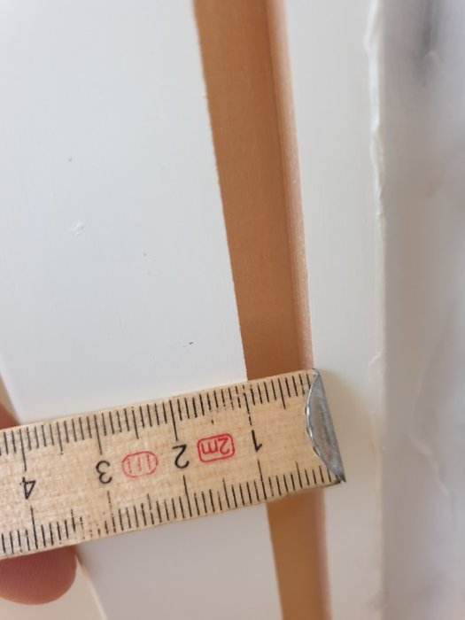 Mått på fönstersmygens tappar jämförs med urfräst spår på karmen med en tumstock.