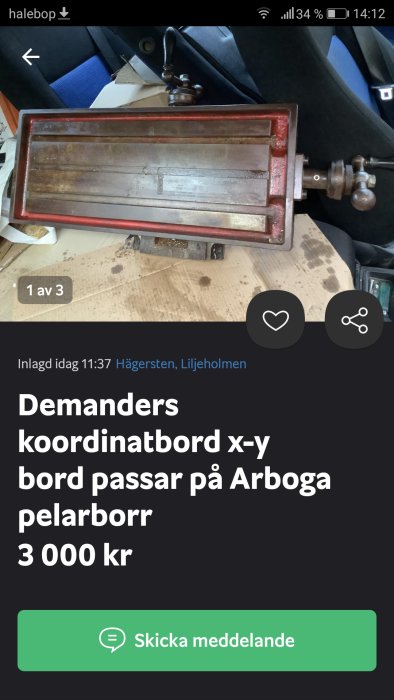 Rödmålat, begagnat koordinatbord för pelarborr, visas på en arbetsbänk.