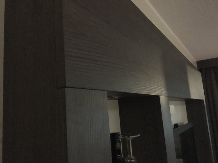 Träpanel på hotellrums väggar och takstruktur, mörk finish, naturlig textur, undvik plastkänsla.
