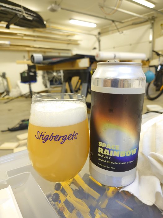 Ölglas märkt "Stigbergets" och burk "Space Rainbow", på verktygsbänk i garage.