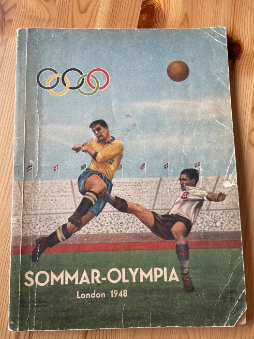 Gammalt programblad för Sommar-OS i London 1948 med illustration av fotbollsspelare och Olympiska ringar.