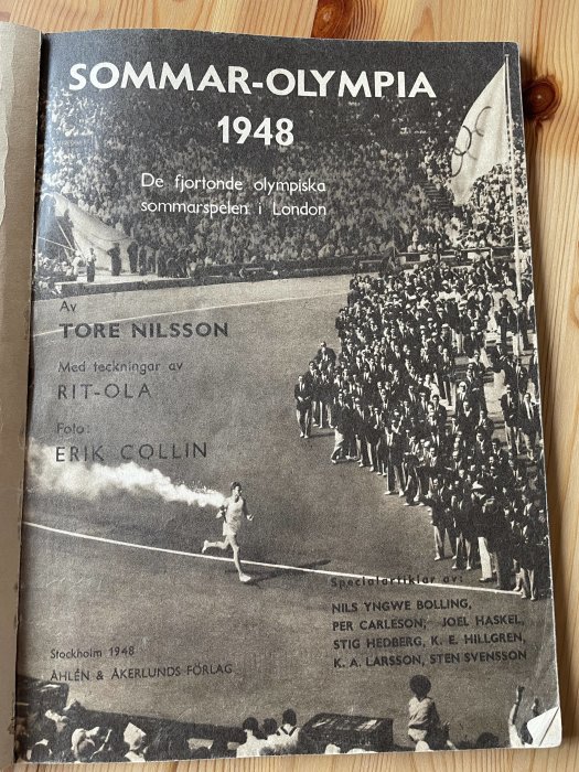 Omslag av boken "SOMMAR-OLYMPIA 1948" som visar en olympisk fackelbärare och idrottare som marscherar.