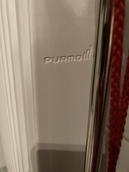 Närbild på en vit radiator med märkningen 'purmo' och en röd pil som pekar på platsen där en termostat bricka saknas.