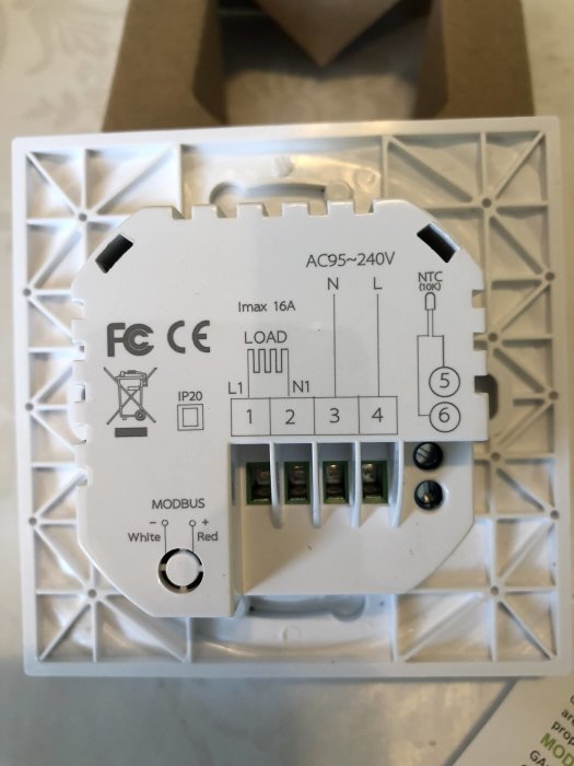 En ny termostat för värmestyrning med tydliga etiketter för kablage och inställningar, inklusive MODBUS-anslutning.