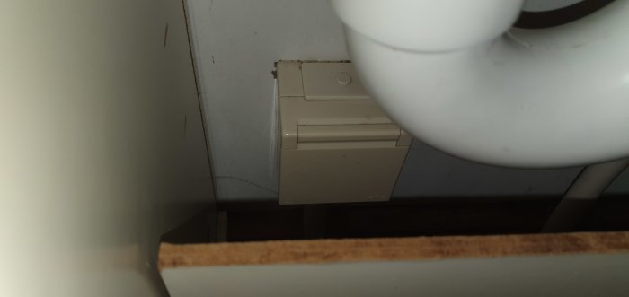 Vinkelvy inuti köksskåp visar bakvägg och kantlist där en diskmaskin ska installeras.
