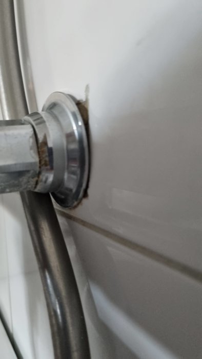 Glipa runt röranslutning till vit vägg med tätning som ser gammal och sliten ut.