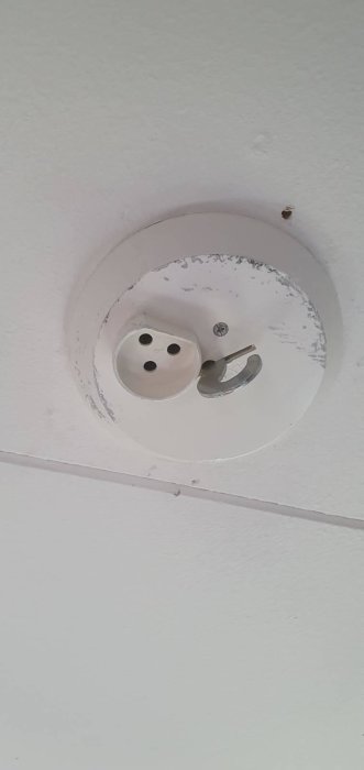 Takuttag och krok för taklampa, målningen kring uttaget är skadad.