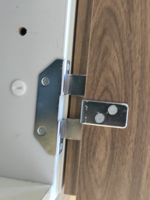 Närvarande bild på ett Kalmar gångjärn installerat på en dörr, möjligtvis inför renovering.