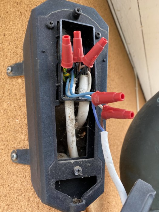 Öppen elektrisk armatur med synliga ledningar och anslutningar, inklusive röret som leder till sensorn.