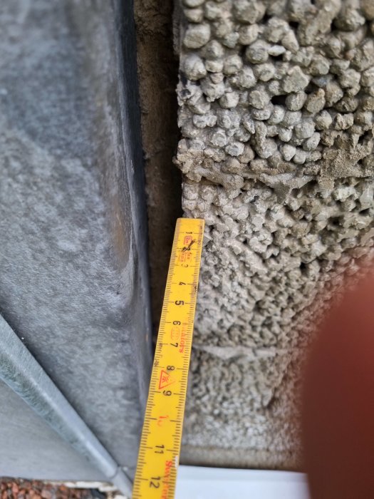 Måttband som visar en vägg som är 4.5 cm innanför en annan vägg under renovering.