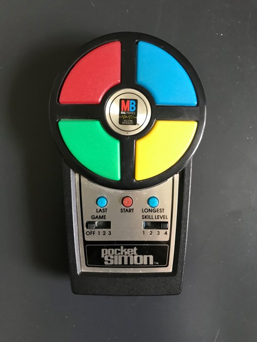 Pocket Simon, ett elektroniskt minnesspel från 1980 med färgade fält, används av barnbarn.