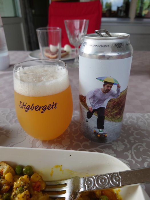 Ölglas märkt Stigbergets och ölburk med Northern Monk, person skateboardåkning, matrester i förgrunden.