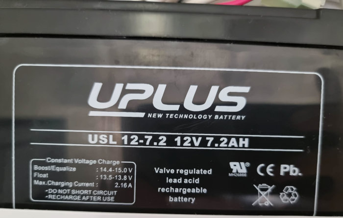 Bild på ett UPLUS 12V 7.2Ah bly-syra batteri med laddningsspecifikationer och säkerhetsinstruktioner.