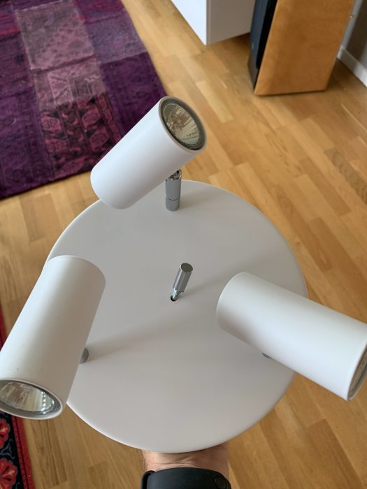 Takarmatur med tre spotlighter hålls upp, förfrågan om byte av drivdon till LED.