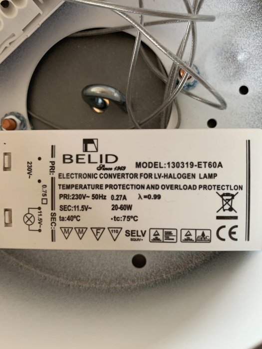 Etikett på ett trasigt elektroniskt drivdon till lågvolts-halogenlampa märkt "BELID", med tekniska specifikationer.