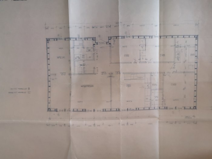 Arkitektritning av husrums layout med måttsättning, väggar och dörrar synliga.