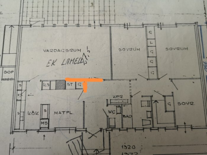 Ritning av en bostadsplan med en markerad del i orange där en vägg mellan vardagsrum och kök planeras att tas upp.