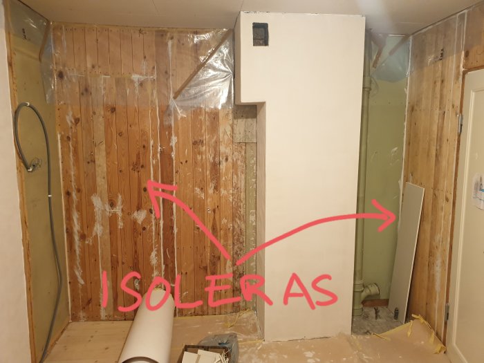 Renoveringsrum med en vägg av stående plank och textmarkering som anger planerad ljudisolering.