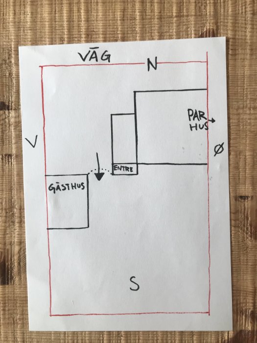 Handritad skiss av en fastighetsplanlösning med parhus, gästhus och entré markerad.