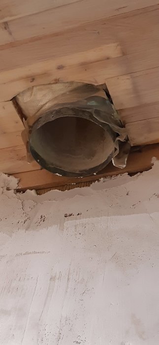 Ventilationsrör som sticker ut från en vit vägg i ett pågående byggprojekt.