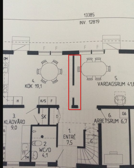 Ritning över en lägenhet med rödmarkering runt en mittvägg för diskussion om borttagning.