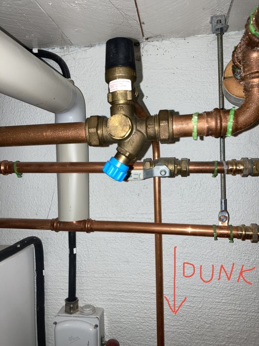 Säkerhetsventil och rörledningar med noterad plastdunk under, möjlig läckagepunkt.