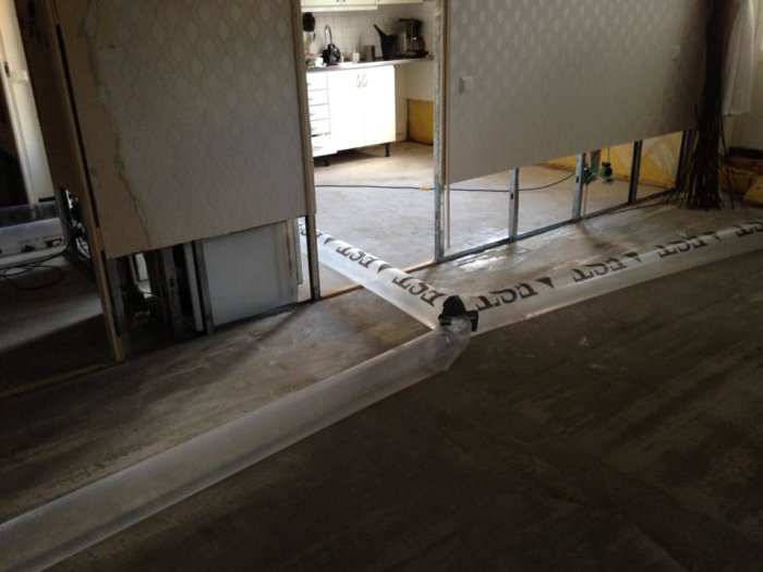 Vannskader i leilighet, åpen vegg og gulv med avdekkede stendere, tørking og reparasjon pågår etter lekkasje fra oppvaskmaskin.