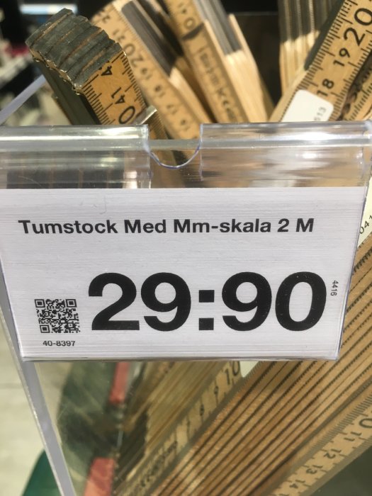 Tumstockar med millimeterskala på prislapp i en butik.