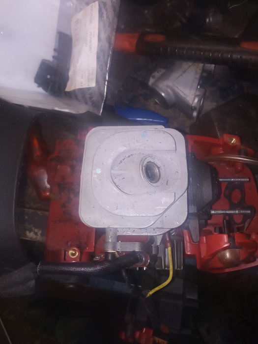 Orienterad bild av en motor med märkningar och elektriska ledningar i en verkstadsmiljö.