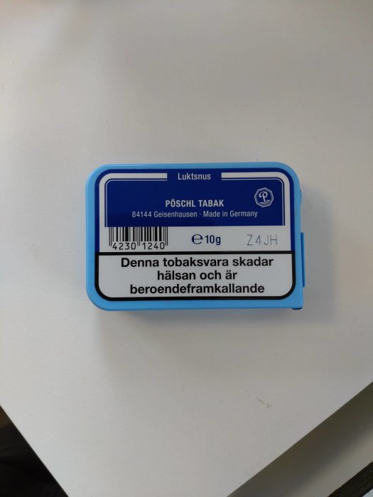 Blå förpackning av lukt snus från Pöschl Tabak på ett vitt bord.