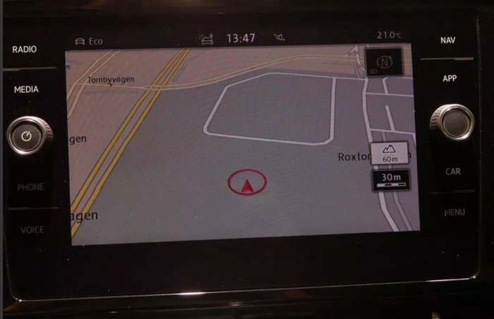 Bilens infotainmentsystem visar GPS-navigation på skärmen med kontroller för radio och telefon.