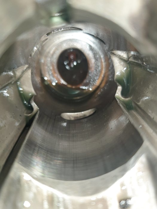 Närvaro av rost och slitage inuti en metallisk cylinder, fotograferad inifrån mot öppningen.