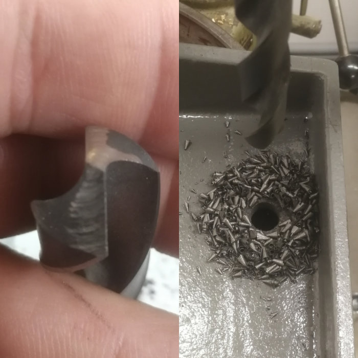 Närbild av en slipad borrspets och en hög borrspån på en bänkslipmaskin.