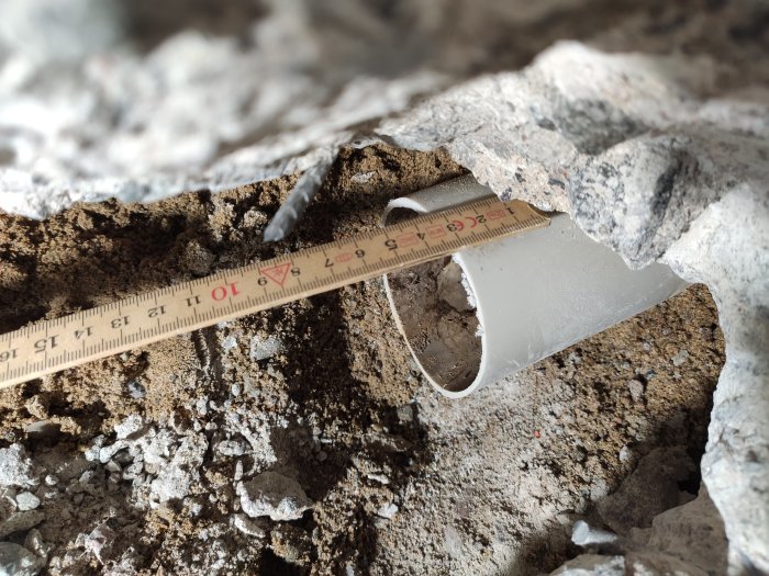 Måttband visar 3 cm rent rör framstickande ur betong efter bilningsarbete.