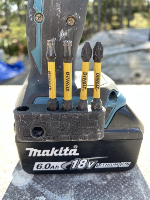 Bitshållare på ett Makita batteri med insatta DEWALT bits.