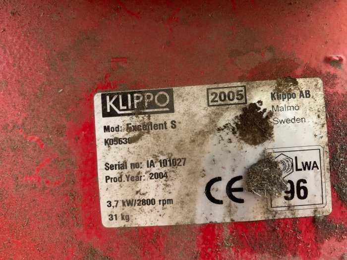 Smutsig typskylt på en röd yta med texten "KLIPPO 2005, Mod: Excellent S, K05630, Malmo Sweden".