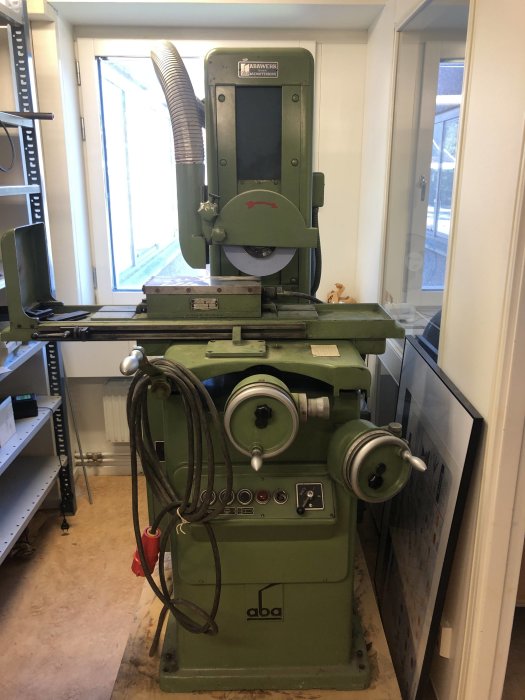 Industriell slipmaskin av märket aba som står i en verkstad.