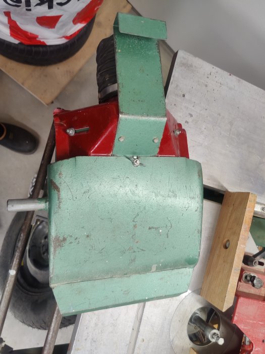 Grönt och rött maskinliknande objekt på en arbetsbänk, eventuell byggutrustning.