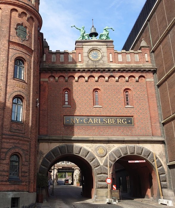 Ingång till det anrika bryggeriet "Ny Carlsberg" med tegelarkitektur och skulpturer på taket.