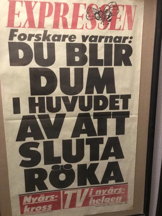 Tidningsurklipp i ram med rubriken "DU BLIR DUM I HUVUDET AV ATT SLUTA RÖKA".