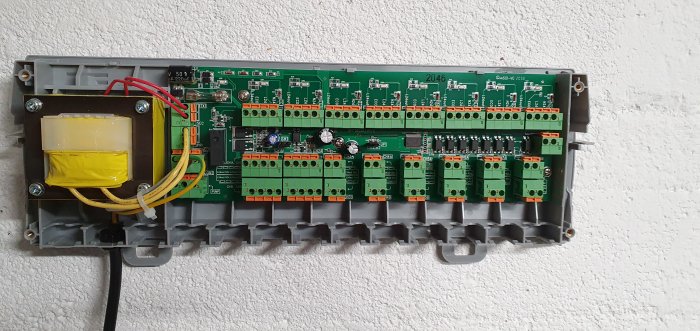 EC8 styrenhet monterad på vit vägg med synliga anslutningar och transformator.