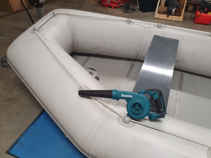 Makita DUB185 blåsare används för att snabbt fylla en gummibåt med luft i ett garage.