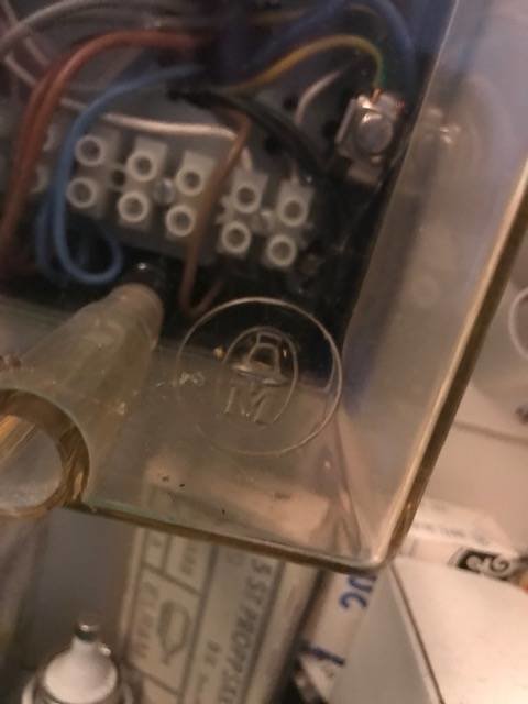 Transparent plastbox med elektriska komponenter och symboler, kopplad till elcentral.