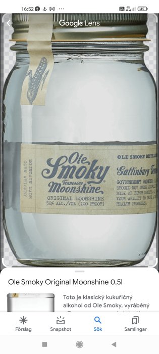 Alternativ text: Glasflaska med etikett för Ole Smoky Tennessee Moonshine, 50% alkohol, öppnad och delvis tom.