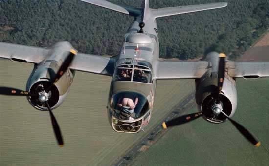 Vy från underifrån av ett flygplan i luften med markerade propellrar och fönster, ingen synlig spricka.