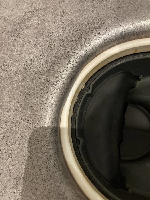 Plastmatta i badrum släppt från klämring runt golvbrunn.