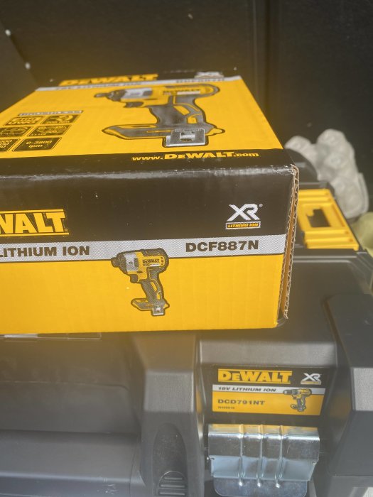 Två kartonger med DeWALT elverktyg, en spikpistol och en dyckertpistol, staplade ovanpå varandra.